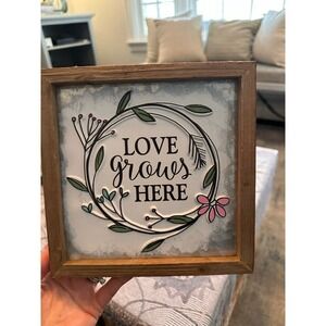 Tin and wood love grows here sign
